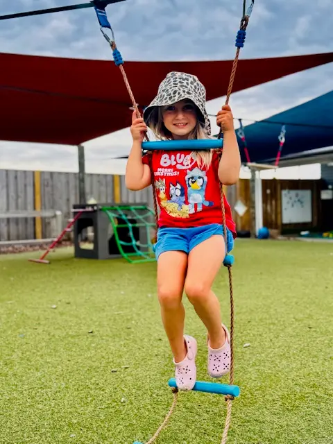 Child enjoying a swing at Ōtipua Grove